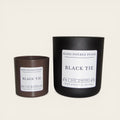 Two candles labeled 'Black Tie' by Hand Poured Peace on a white background