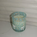 Turquoise ceramic cup with floral patterns on a white background