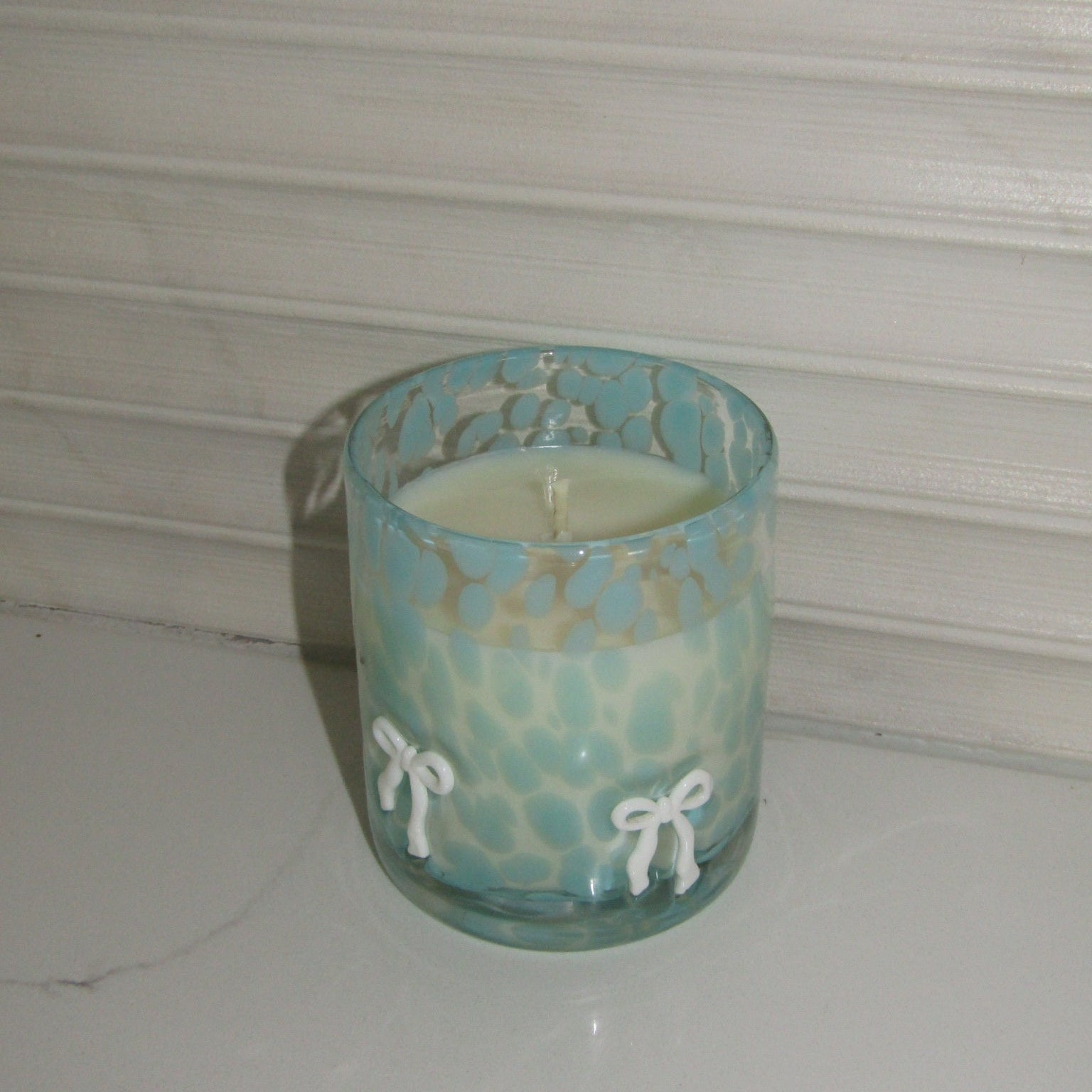 Turquoise ceramic cup with floral patterns on a white background