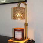 Wall-mounted lamp with decorative glass shade and candle holder against a white wall.