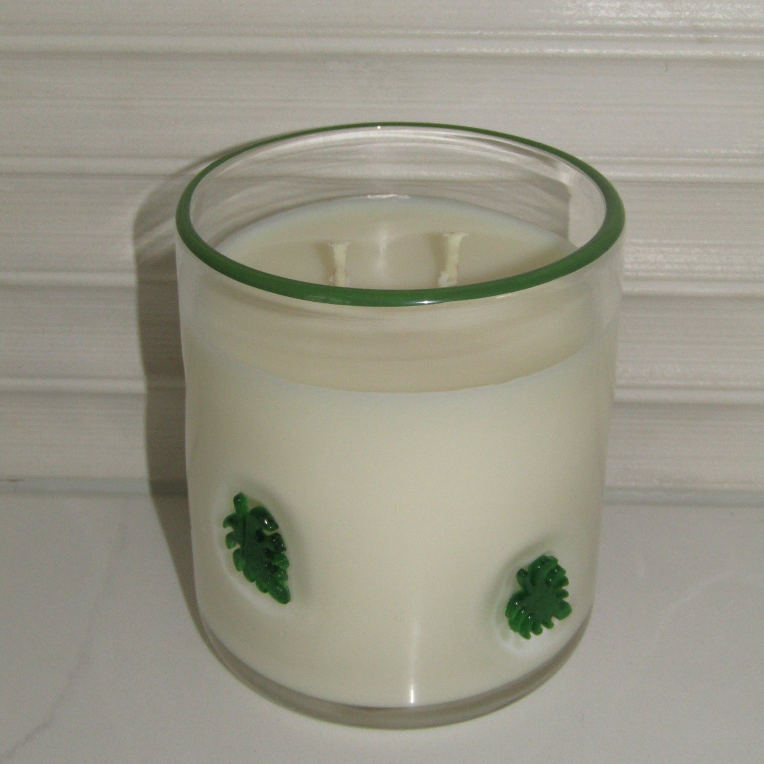 Clear container with green leaf decorations on a white background
