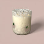 Decorative glass candle holder with marble pattern on a pink background